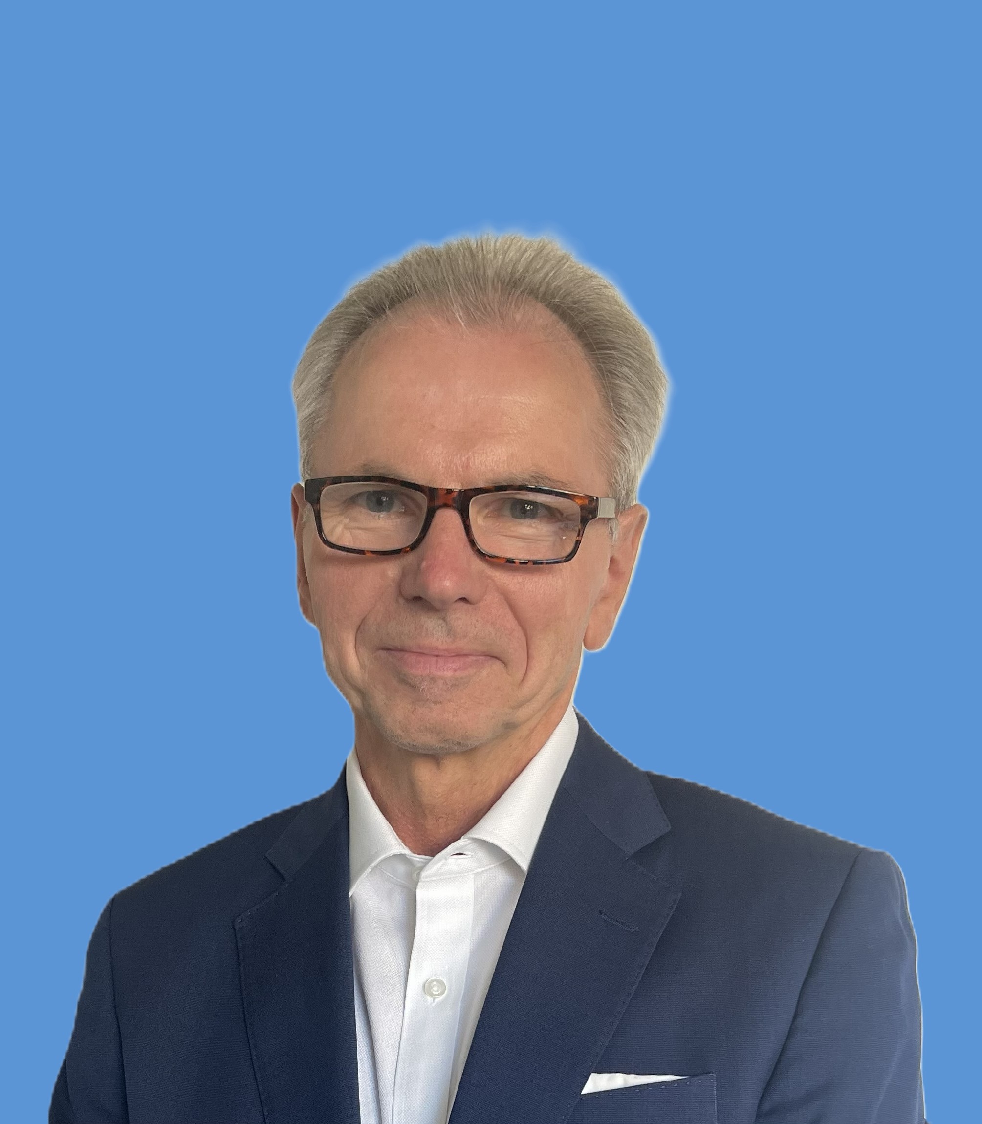 Portrettfoto av formelt kledd mann som smiler til kamera med lukket munn.