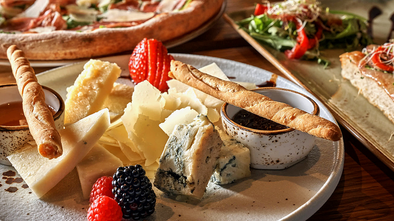 Tapastallerken med forskjellige oster og grissini.