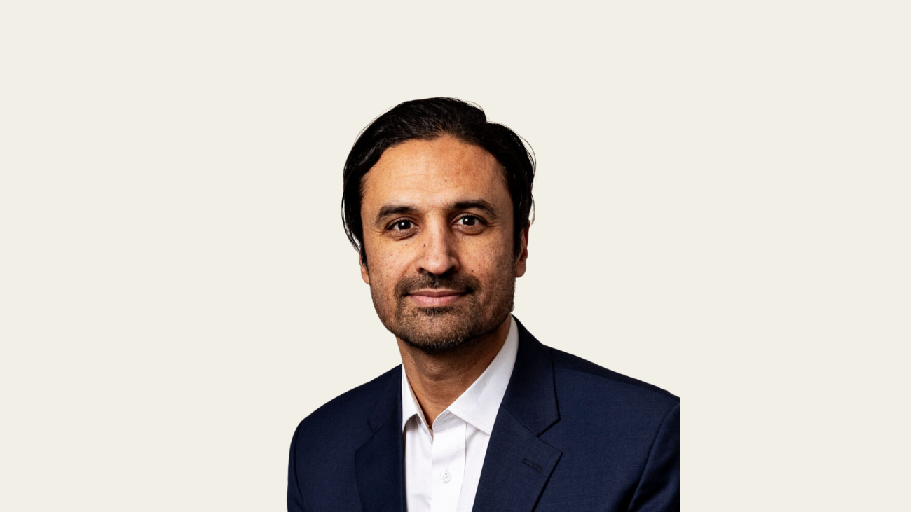 Formelt kledd mann som smiler forsiktig til kamera.