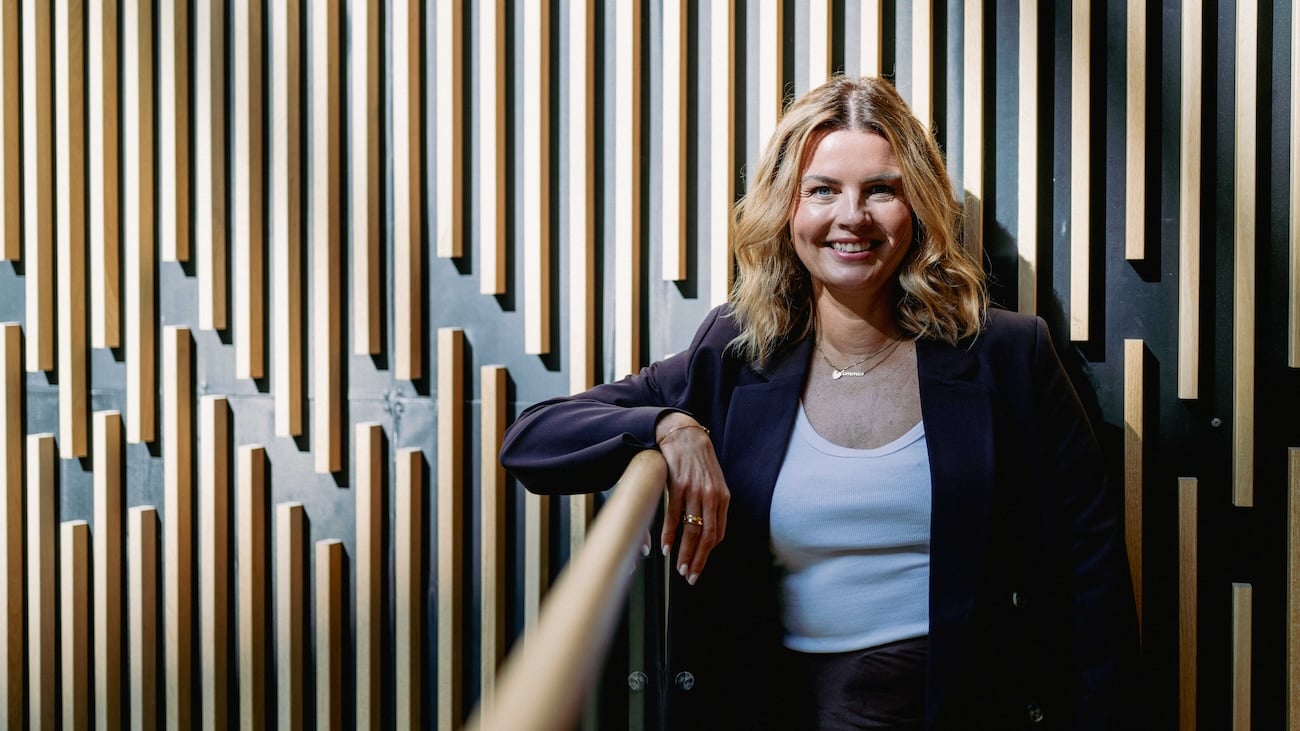 Sittende kvinne som smiler bredt