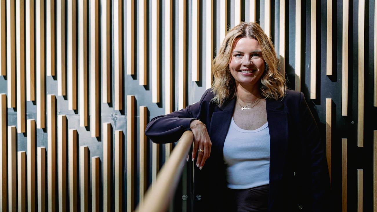 Sittende kvinne som smiler bredt