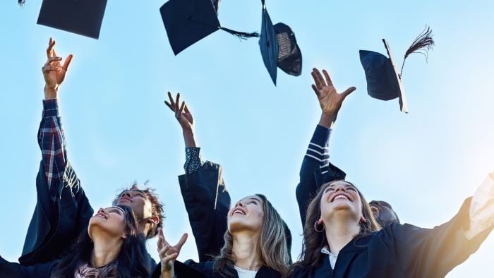 Studenter som er ferdig med studiene og kaster masterluen opp i luften.