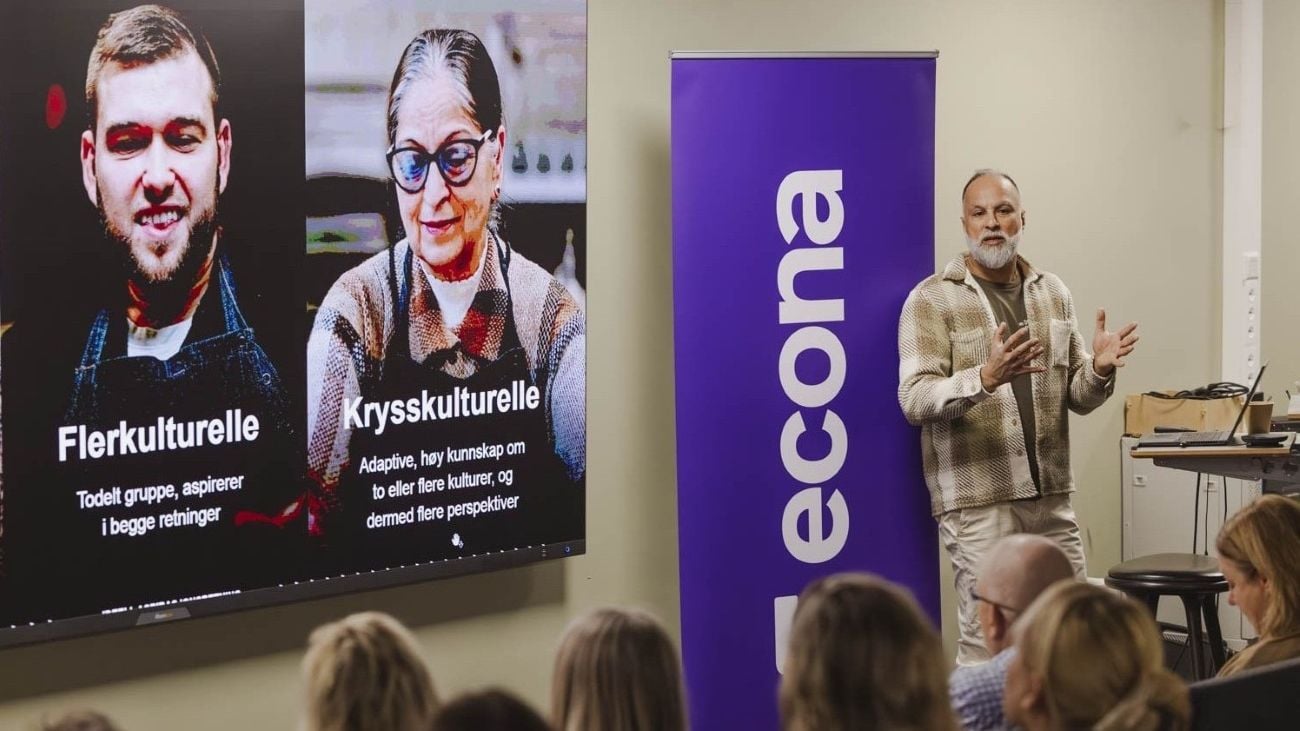 En mann som holder en presentasjon foran en fullsatt sal om sitt arbeid rundt mangfold.