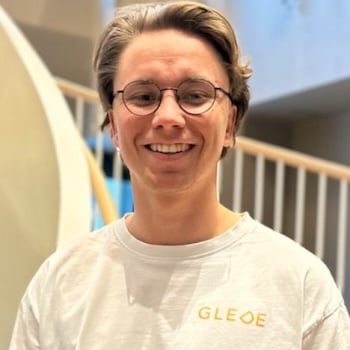 Portrettfoto av ung mann som smiler bredt til kamera.