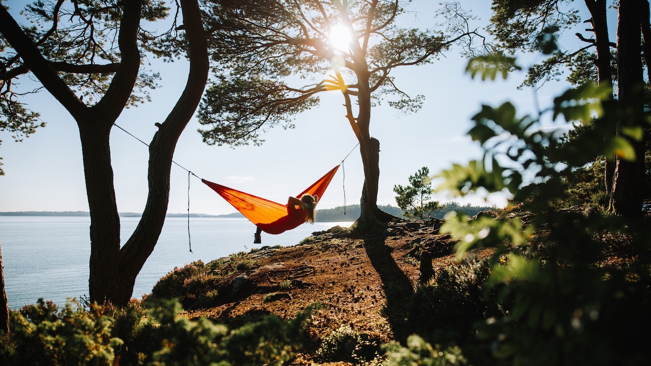 Hengekøye med person i mellom to trær ett sted i Norge. 