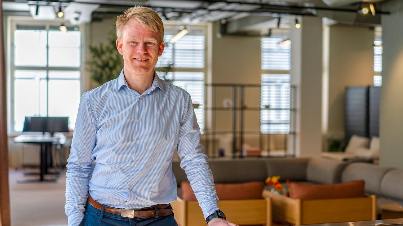 Atle Kolbeinstveit fra Econa står i et lyst kontorlandskap og smiler mot kamera.