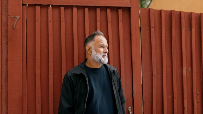  Portrett av mann som lener seg mot rød vegg