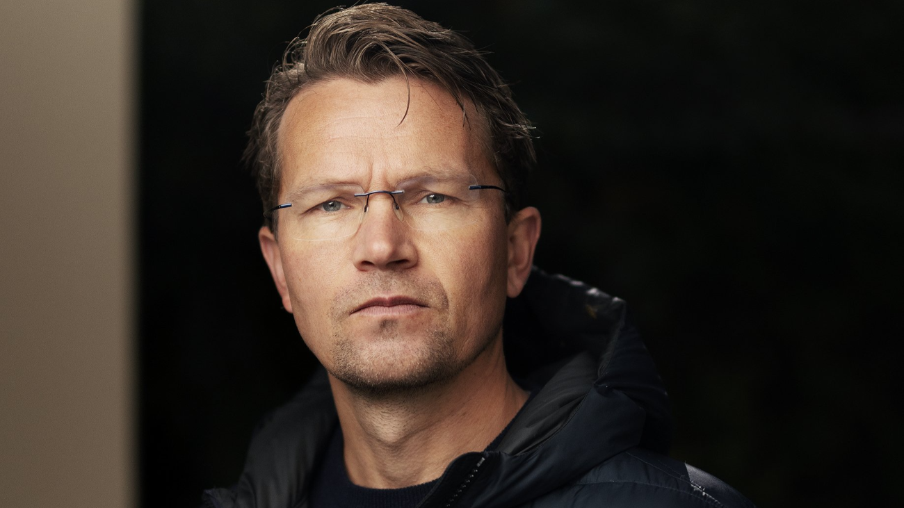 Mann som ser rett inn i kamera med et alvorlig blikk.