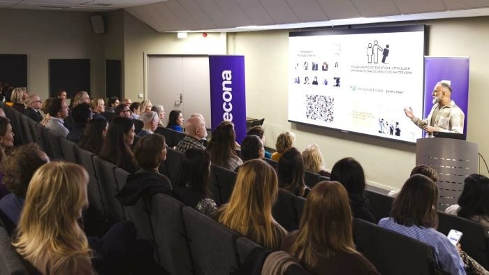 Et fullsatt auditorium under et frokostmøte om mangfold.