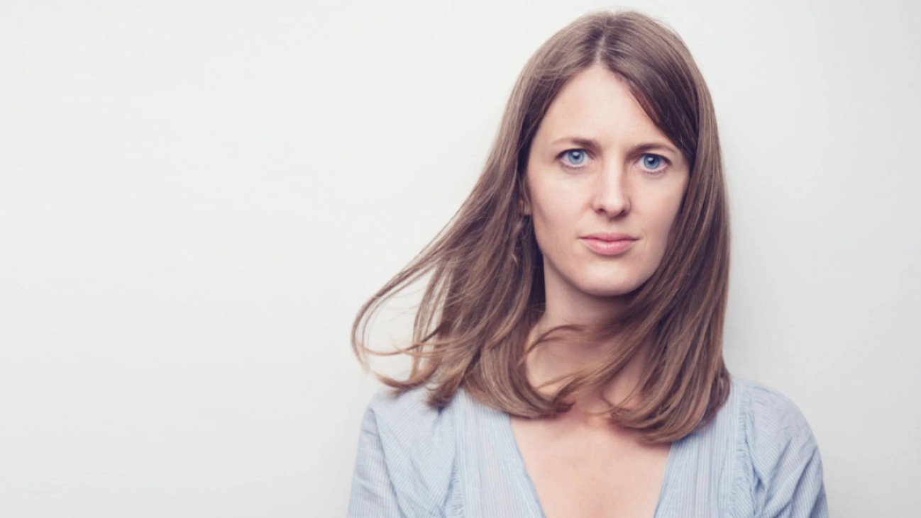 Kvinne som smiler bredt til kamera.