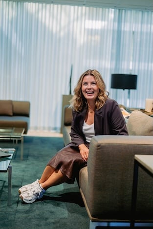 Kvinner sitter i sofa og ser smilende i kamera