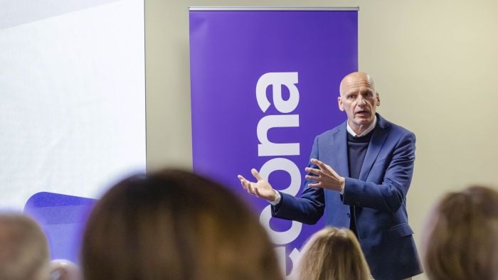 Mann som står og snakker om viktigheten av mangfold foran en fullsatt sal.