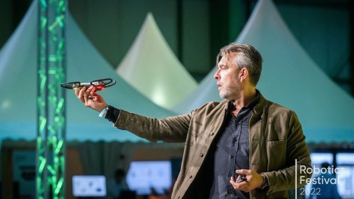 Mann som står og tester en drone under Robotics festival i Dresden.