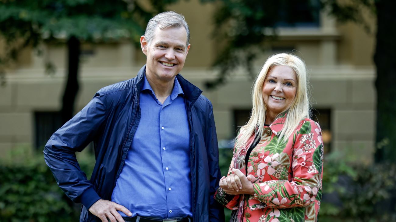 Kvinne og mann som står sammen og smiler til kamera.
