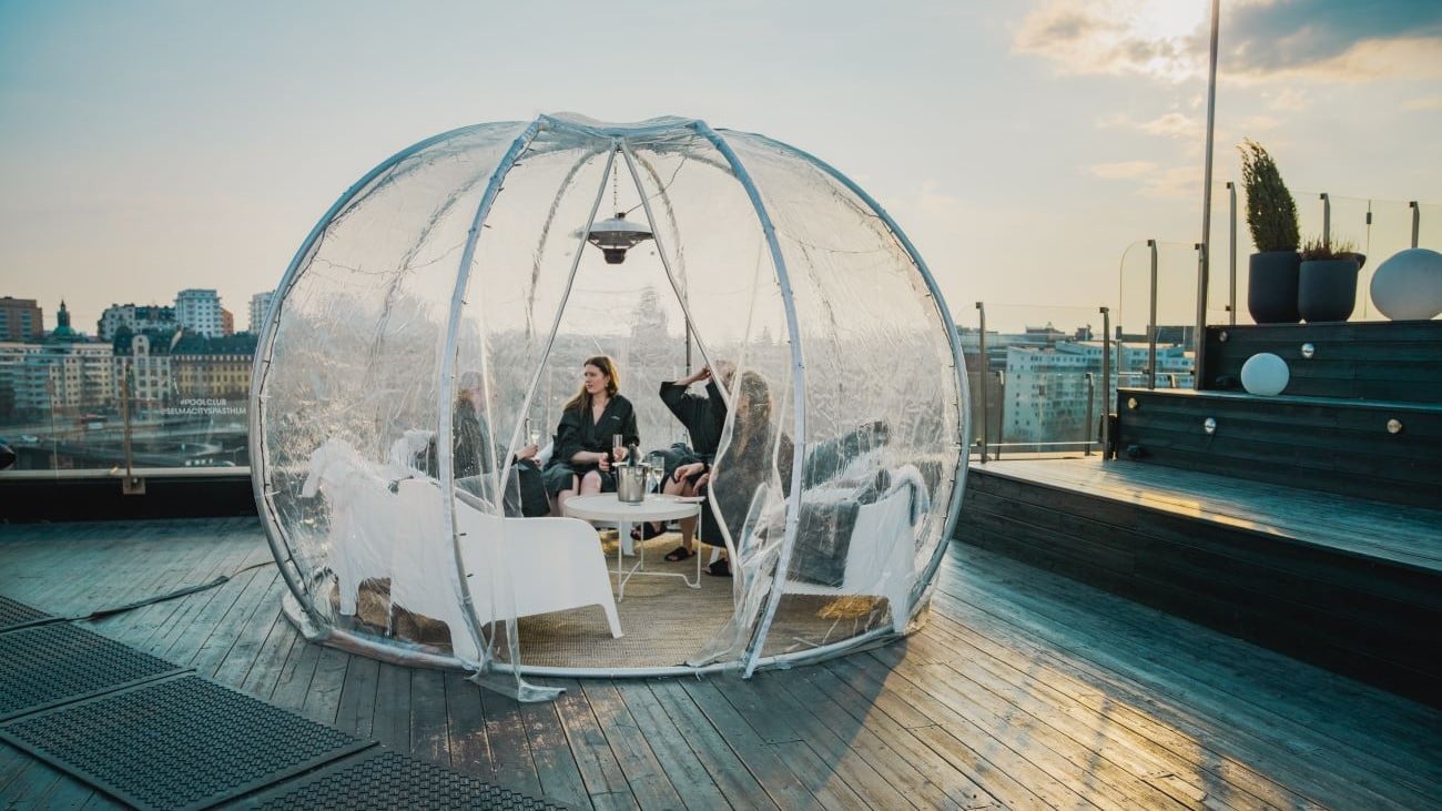 Tre kvinner på spa i en glassigloo på taket av et hotell