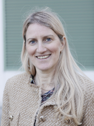 Portettfoto av kvinne som smiler bredt til kamera.