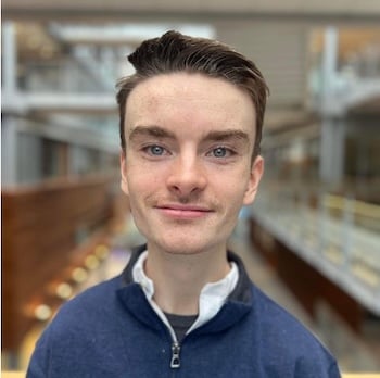 Portrettfoto av ung mann som smiler forsiktig til kamera.