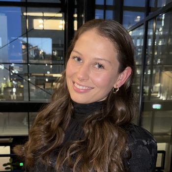 Portrettfoto av ung kvinne som smiler til kamera.