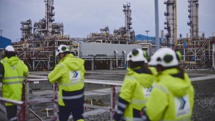 Et prosessanlegg i Rogaland med arbeidere i gule jakker.