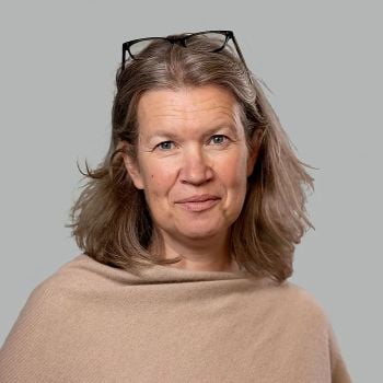 Portrettfoto av kvinne som smiler forsiktig til kamera.