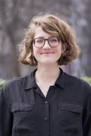 Utendørs portrettfoto av kvinne som smiler.