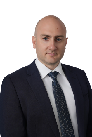 Portrettfoto av formelt kledd mann som smiler forsiktig med øynene.