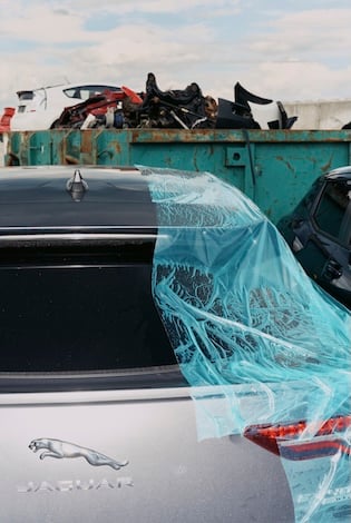 Nærbilde av baksiden av en bilmodell fra Jaguar som står parkert hos Bilias reparasjonsanlegg.