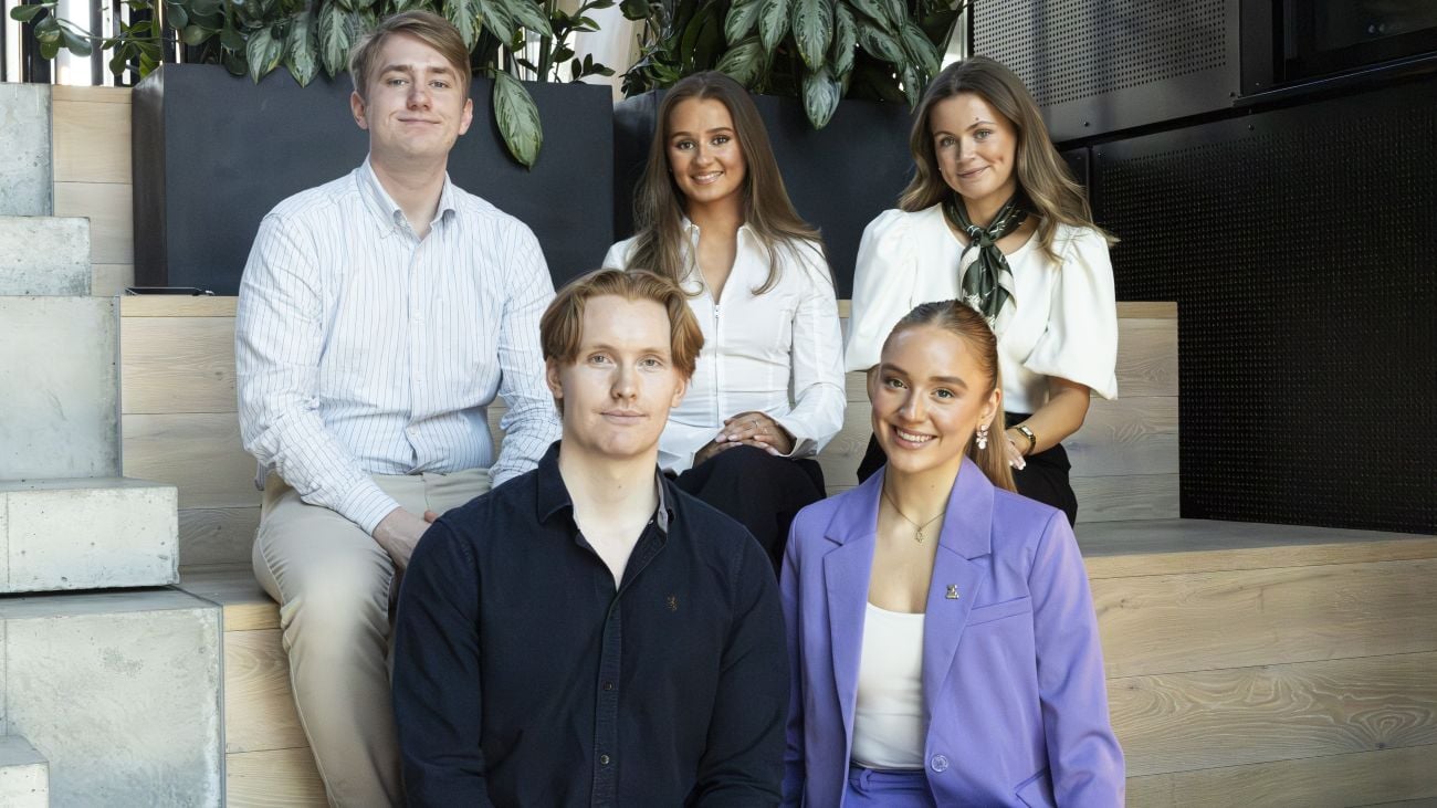 Fem studenter sitter i en trapp. Disse er medlemmer av studentutvalget i Econa i perioden 2026-2027.